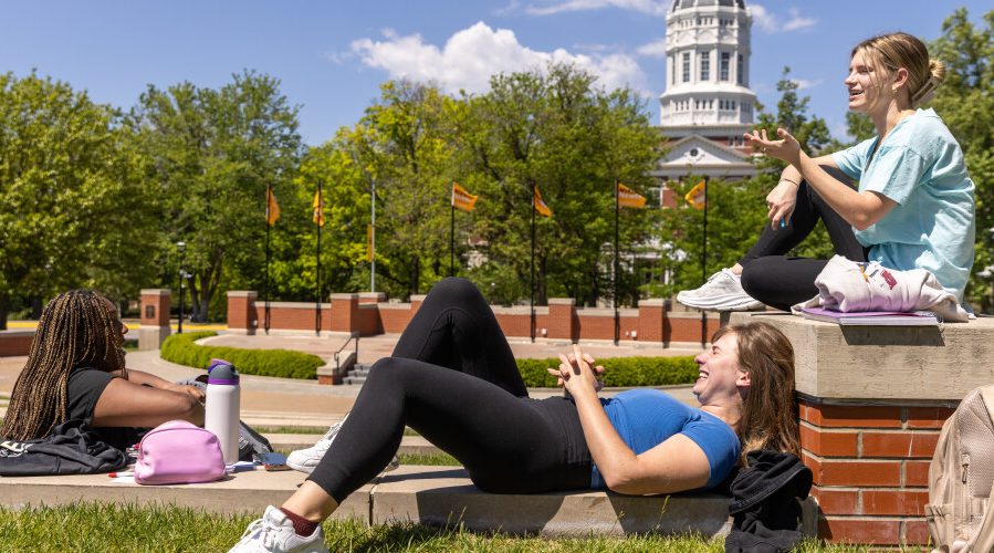 students sitting by speaker's circle enjoying the sun on mizzou's campus in front of jesse hall