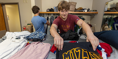 Student folding laundry.