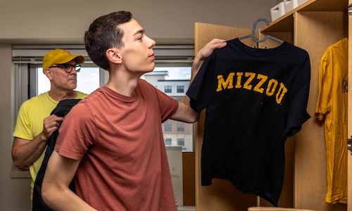 Mizzou student hanging up shirt during welcome week.