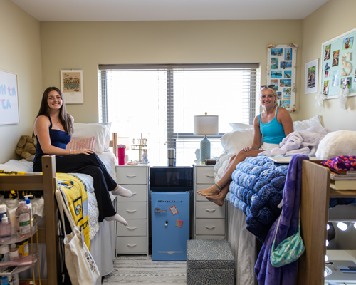 Students with fridge in dorm.